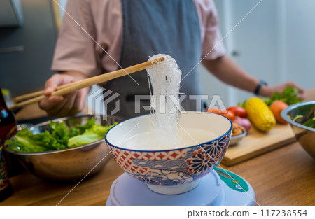 Chef at the kitchen preparing spicy glass noodle salad 117238554