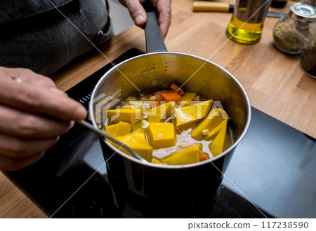Chef at the kitchen preparing pumpkin porridge with tofu and vegetables Chef at the kitchen preparing pumpkin porridge with tofu and vegetables 117238590