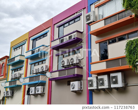 There are numerous air conditioners installed on the exterior of the building 117238763