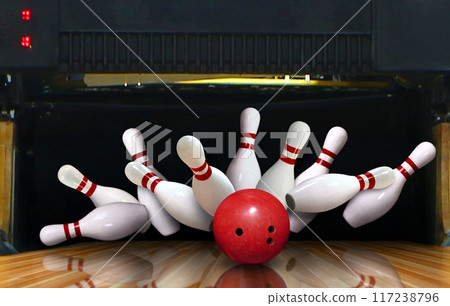 Bowling strike hit with ball hitting ten pins in the alley 117238796