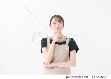 A woman wearing an apron with a thinking expression A woman wearing an apron with a thinking expression 117238832