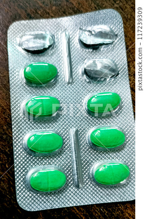 Medicines for fever and allergy are kept on a wooden table 117239309