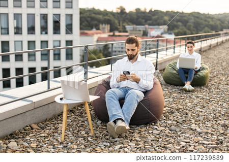 Business professionals working remotely on rooftop office area 117239889