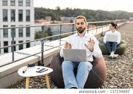 Remote work on rooftop with laptops and bean bags Remote work on rooftop with laptops and bean bags 117239897