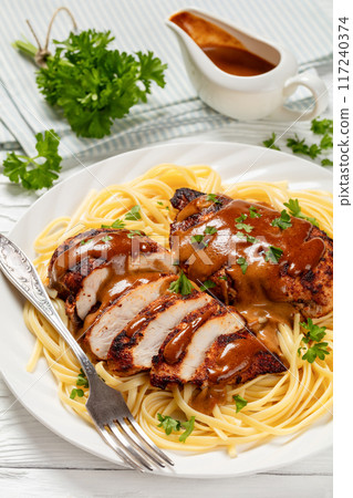 Chicken Lazone with sauce and linguine on plate Chicken Lazone with sauce and linguine on plate 117240374