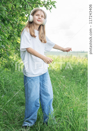 A child with headphones listening to music and dancing A child with headphones listening to music and dancing 117243406