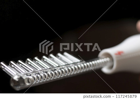Close up shot of the high frequency comb tool for hair and scalp treatment. Close up shot of the high frequency comb tool for hair and scalp treatment. 117245879