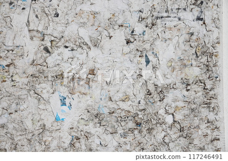 Plywood ad board with leftover scraps of paper. Plywood ad board with leftover scraps of paper. 117246491