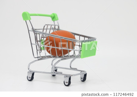 Raw egg in a grocery basket on a white background. Healthy breakfast ingredient.  117246492