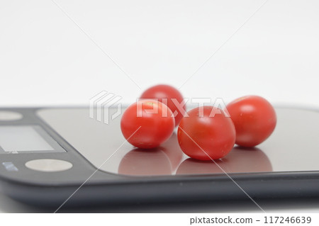 Cherry tomatoes on a kitchen scale, selective focus. Expensive disposable tomato 117246639