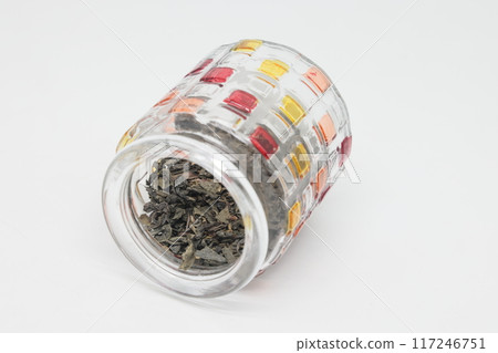 green tea and an openwork colored glass jar on a white background, a healthy drink, proper nutrition green tea and an openwork colored glass jar on a white background, a healthy drink, proper nutrition 117246751