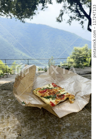 Snack on mountain. Focaccia, pizza and traditional Italian cuisine in nature. Vacation, tourism on Ligurian coast. Snack on mountain. Focaccia, pizza and traditional Italian cuisine in nature. Vacation, tourism on Ligurian coast. 117247133