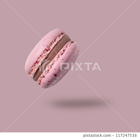 Fly french pink macaroon on a pink background. Concept levitation food. 117247538