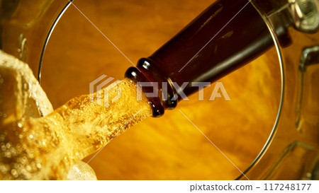 Freeze motion of pouring beer into pint . Unique angle of view from the bottom of the glass . 117248177
