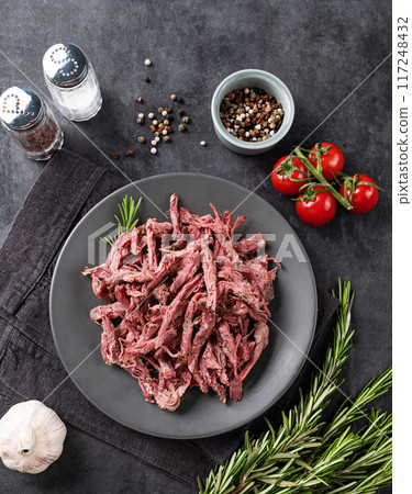 Traditional barbecue torn beef or lamb meat with bbq sauce, fresh tomatoes and herbs  117248432