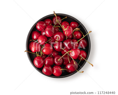 Fresh cherries in a black bowl on a white isolated background. Top view and copy space Fresh cherries in a black bowl on a white isolated background. Top view and copy space 117248440