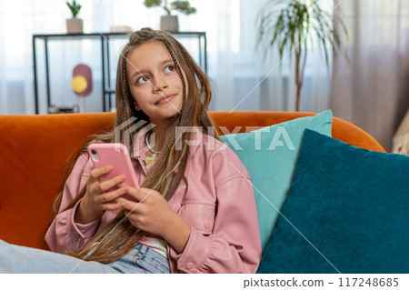 Young girl texting share messages content on smartphone social media applications online at home 117248685