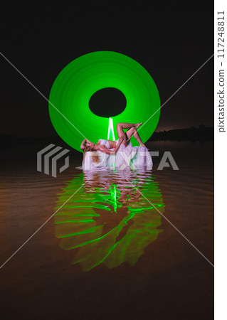 Young slim girl posing in water with abstract green light effect Young slim girl posing in water with abstract green light effect 117248811