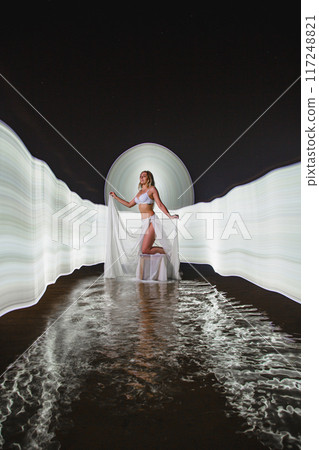 Young slim girl posing in water with abstract light effect Young slim girl posing in water with abstract light effect 117248821