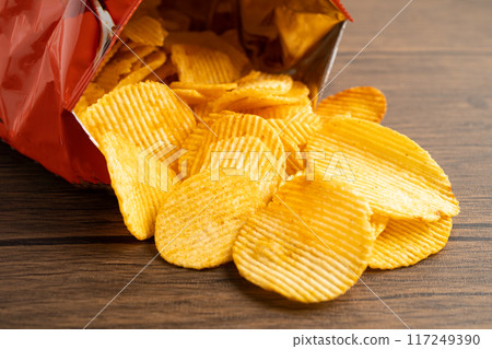 Potato chips, delicious BBQ seasoning spicy for crips, thin slice deep fried snack fast food in open bag. 117249390