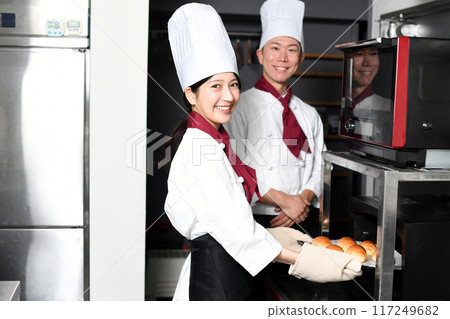 微笑的亞洲男人和女人在廚房裡做麵包 117249682