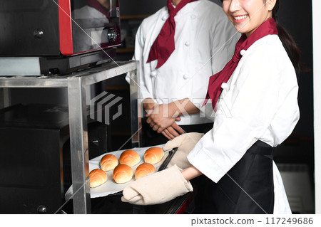 微笑的亞洲男人和女人在廚房裡做麵包 117249686