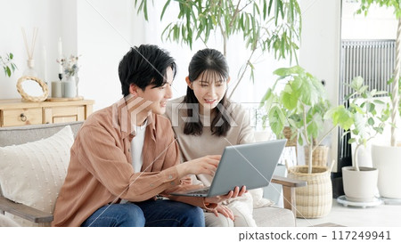 Couples browsing real estate and travel sites 117249941