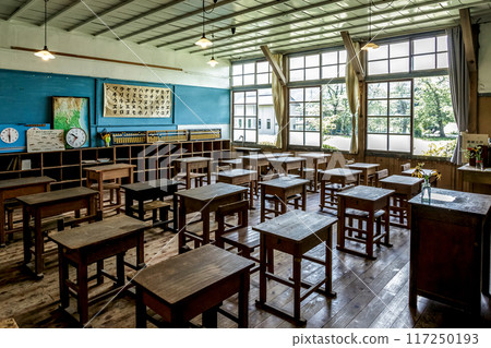 A retro classroom lit by bare light bulbs and with summer sunlight streaming in through the windows A retro classroom lit by bare light bulbs and with summer sunlight streaming in through the windows 117250193