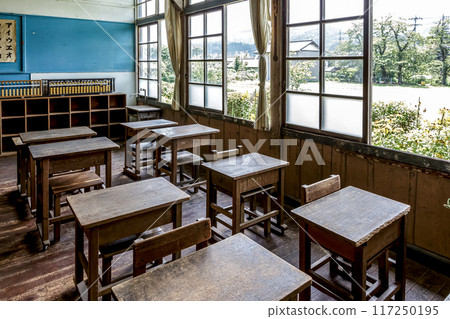 Desks in a retro classroom with summer sunlight streaming in through the windows 117250195