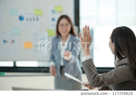 A woman is giving a presentation to a group of people A woman is giving a presentation to a group of people 117250628