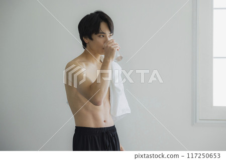 A young man drinking water A young man drinking water 117250653