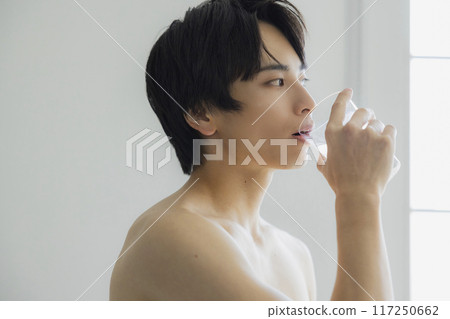 A young man drinking water A young man drinking water 117250662