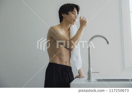 A young man drinking water A young man drinking water 117250673