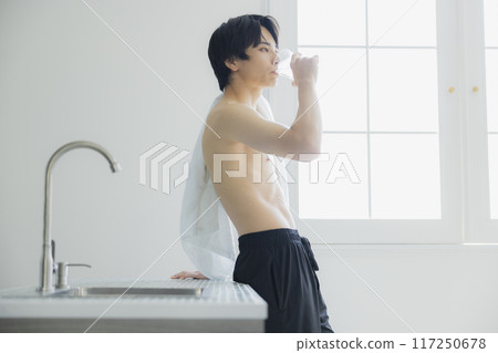 A young man drinking water 117250678