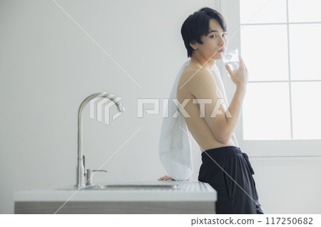 A young man drinking water 117250682