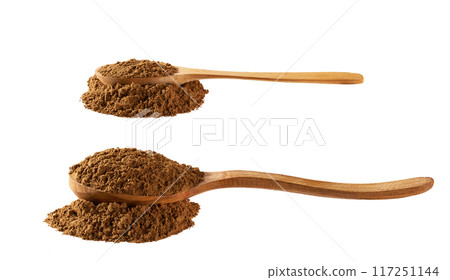 cinnamon powder poured out of a wooden spoon isolated on a white background. 117251144