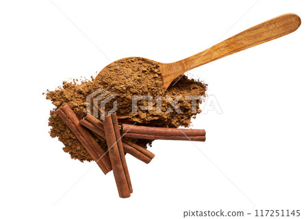 cinnamon powder in a wooden scoop and cinnamon sticks isolated on a white background, top view. 117251145