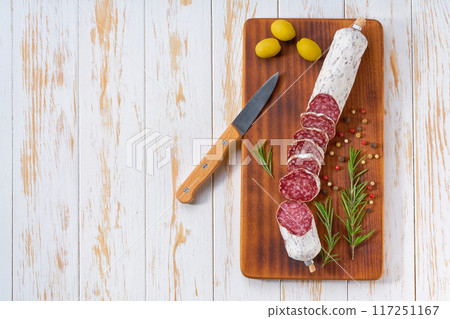 Sliced salami sausage on wooden table, top view. Sliced salami sausage on wooden table, top view. 117251167