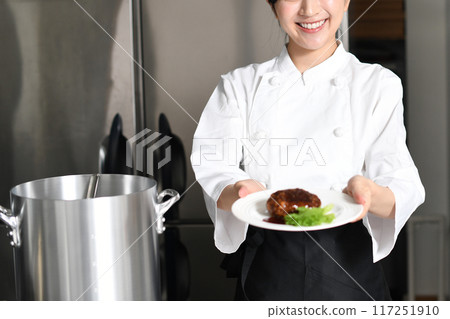 供應肉類菜餚的年輕亞洲女廚師 117251910