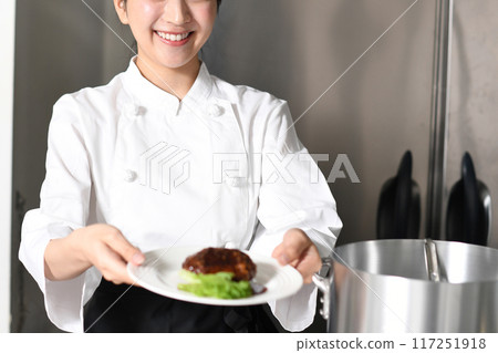 Young asian female chef serving meat dishes 117251918