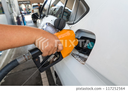Close Up pumping gasoline fuel nozzle in tank for car at gas station. 117252564