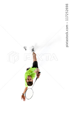 Vertical top view image of young concentrated man, badminton player in full motion, serving shuttlecock with racket, training isolated on white background Vertical top view image of young concentrated man, badminton player in full motion, serving shuttlecock with racket, training isolated on white background 117252698