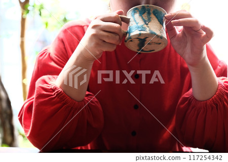 A woman drinking coffee A woman drinking coffee 117254342
