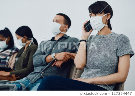 Woman calling while traveling with covid and waiting in line at airport while wearing a mask for protection. For hygiene and healthcare security, follow coronavirus social distance regulations 117254447