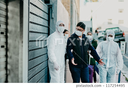 Man breaking covid regulation getting taken away or arrested by healthcare workers wearing hazmat protective suits. Male removed for not following the rules or restrictions of coronavirus pandemic Man breaking covid regulation getting taken away or arrested by healthcare workers wearing hazmat protective suits. Male removed for not following the rules or restrictions of coronavirus pandemic 117254495