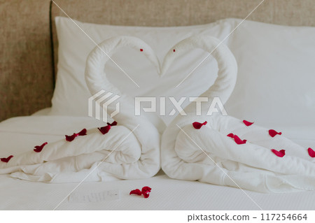 Sweet room in holiday, Swan towel decoration on bed with white pillow in bedroom interior. High quality photo 117254664