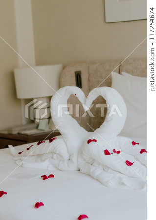 Sweet room in holiday, Swan towel decoration on bed with white pillow in bedroom interior. High quality photo 117254674