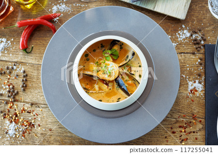 Shrimp Bisque with Seafood. King prawn, blue mussels, cod, whipped cream. Delicious traditional food closeup served for lunch in modern gourmet cuisine restaurant Shrimp Bisque with Seafood. King prawn, blue mussels, cod, whipped cream. Delicious traditional food closeup served for lunch in modern gourmet cuisine restaurant 117255041
