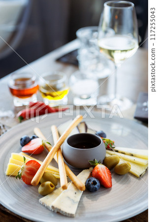 Cheese platter for two: Goat cheese cream, gorgonzola, camembert, grissini and fig jam. Delicious healthy Italian traditional food closeup served for lunch in modern gourmet cuisine restaurant 117255043