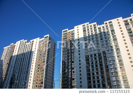 A long row of tall buildings set against a clear blue sky A long row of tall buildings set against a clear blue sky 117255325